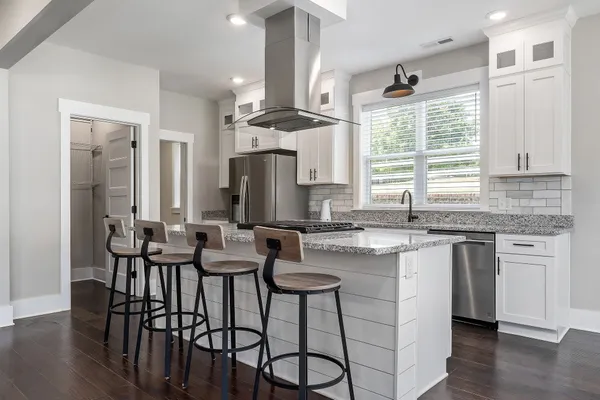 a kitchen with stainless steel appliances granite countertop a stove and white cabinets