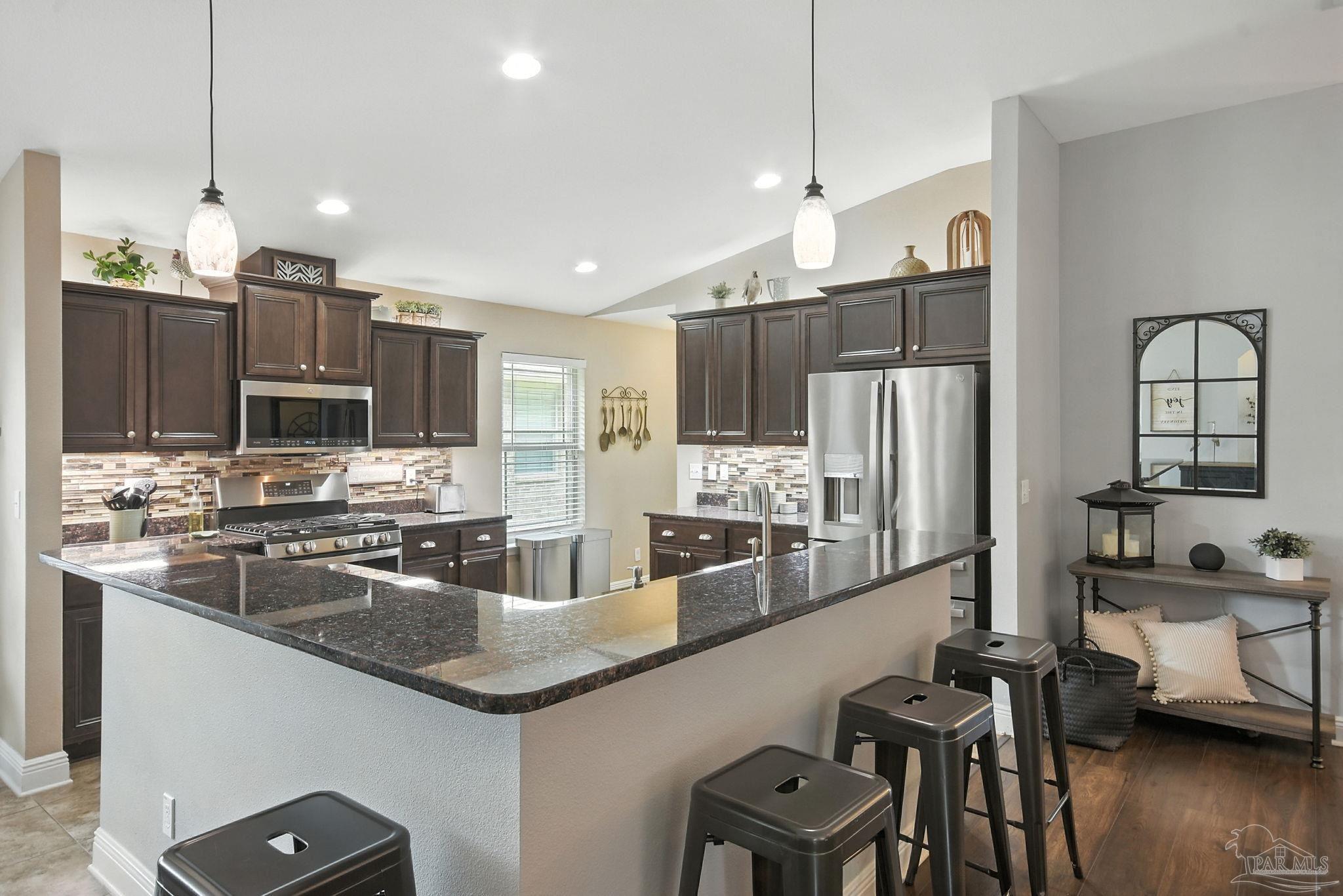 2587 Fiddlers Circle Cantonment, FL 32533 - Photo 27 of 66 a kitchen with stainless steel appliances granite countertop a sink refrigerator and cabinets