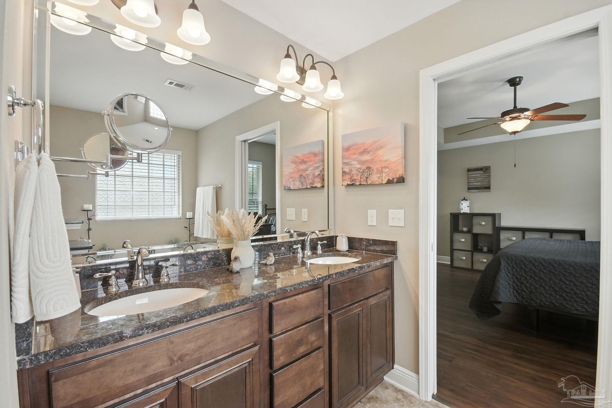 2587 Fiddlers Circle Cantonment, FL 32533 - Photo 34 of 66 a bathroom with a granite countertop sink a large mirror and a shower