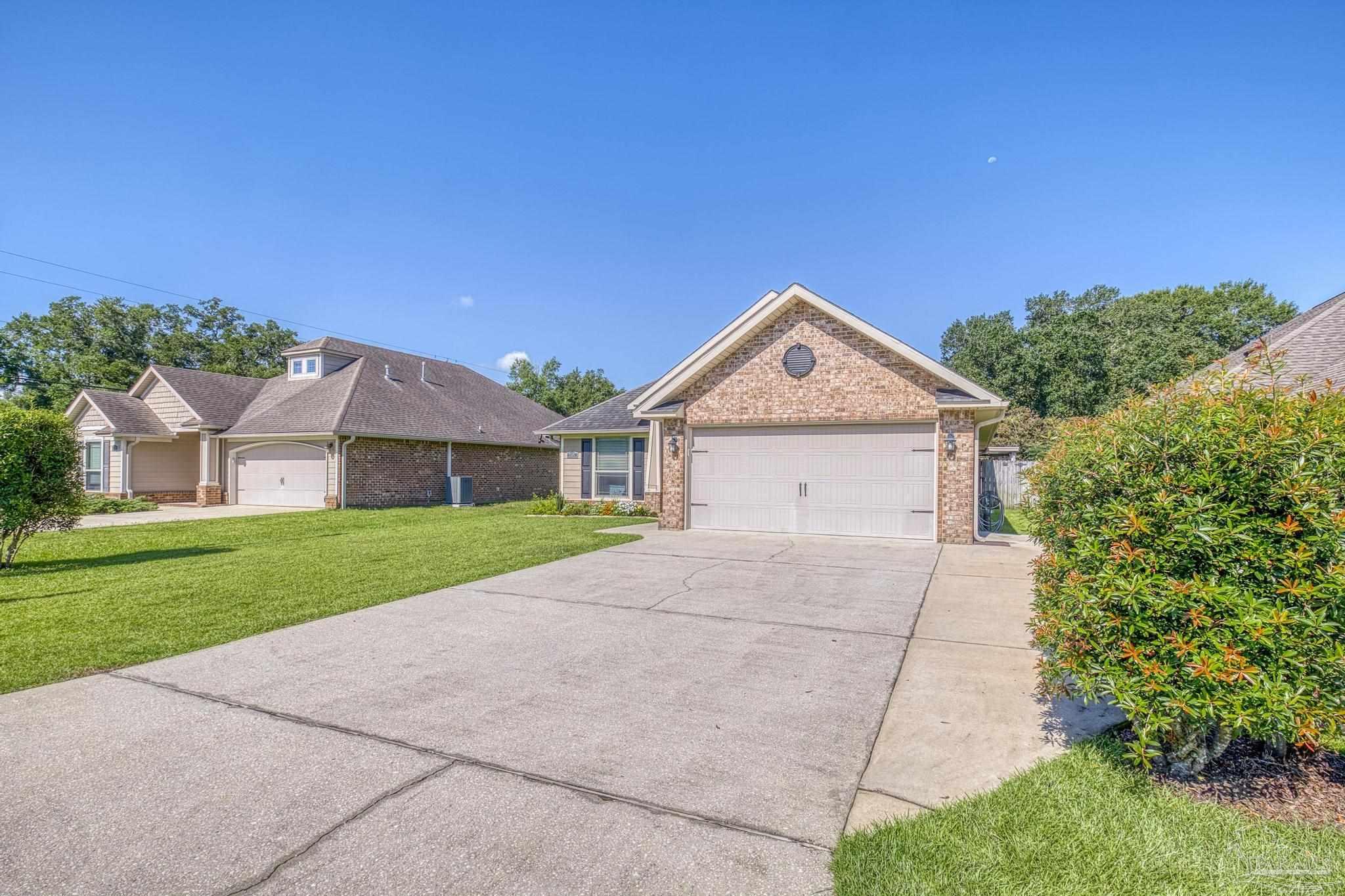 2587 Fiddlers Circle Cantonment, FL 32533 - Photo 59 of 66 a front view of a house with a yard and garage