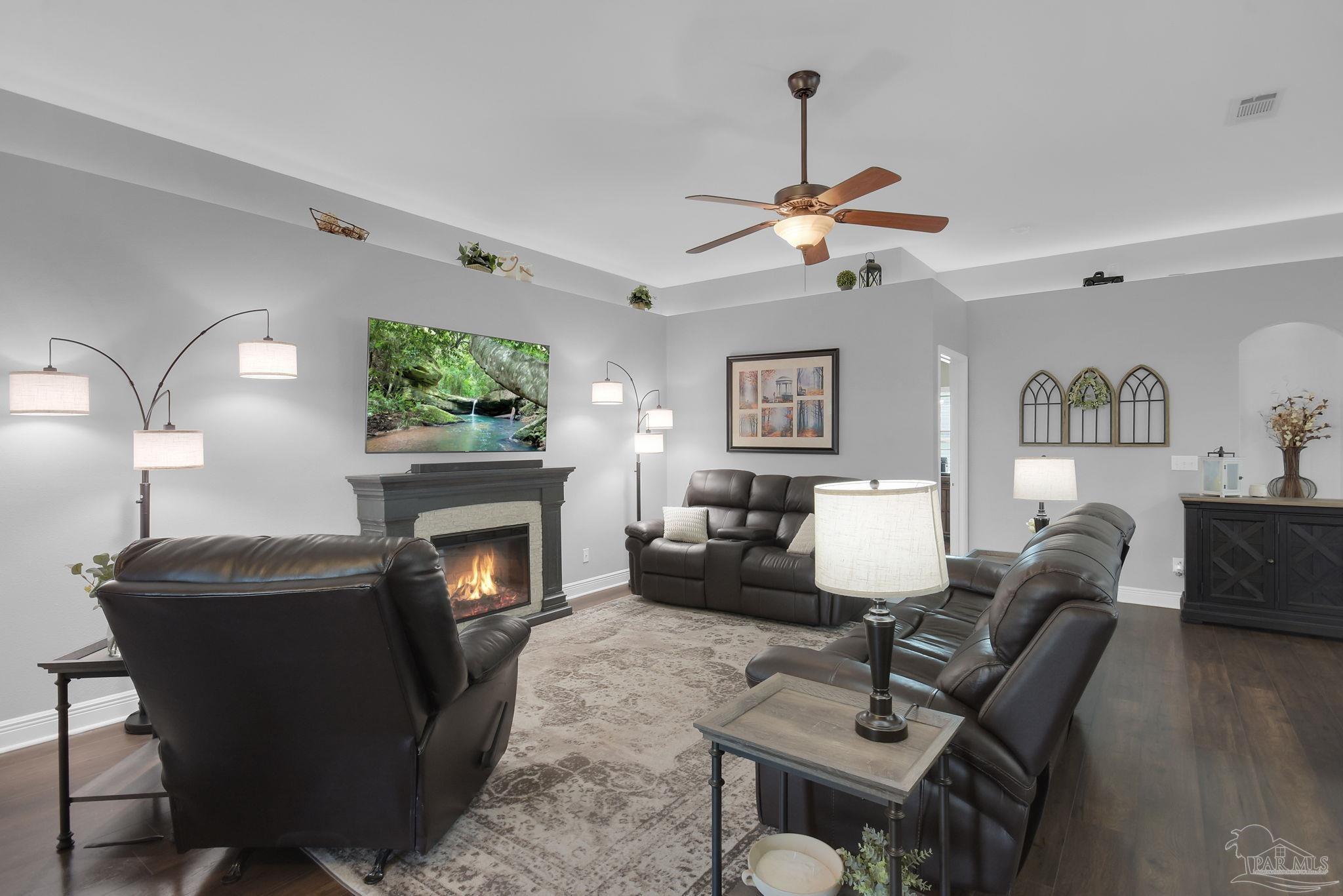 2587 Fiddlers Circle Cantonment, FL 32533 - Photo 8 of 66 a living room with furniture a fireplace and a chandelier