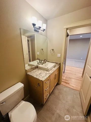 a bathroom with a granite countertop toilet sink and mirror