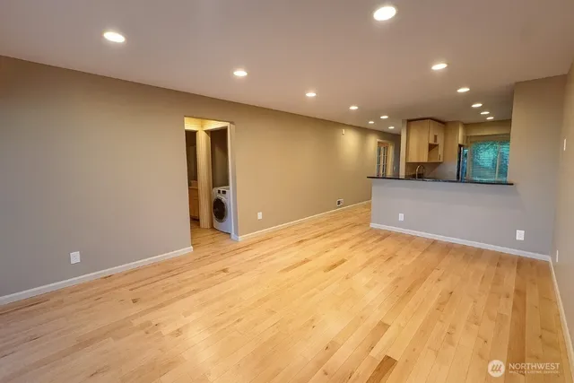 a view of an empty room with wooden floor