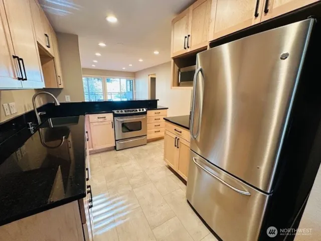 a kitchen with stainless steel appliances a refrigerator and a stove