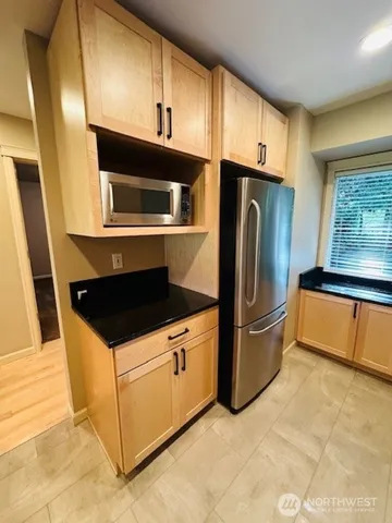 a kitchen with stainless steel appliances granite countertop a refrigerator stove and microwave