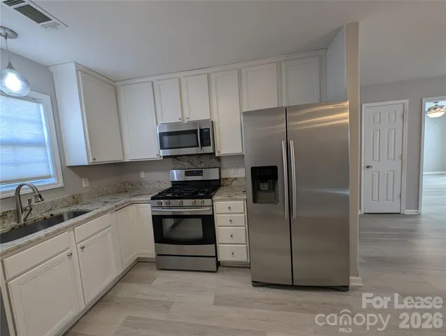 a kitchen with a refrigerator stove and sink