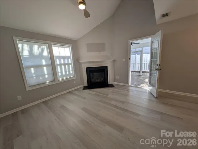 wooden floor fireplace and windows in an empty room