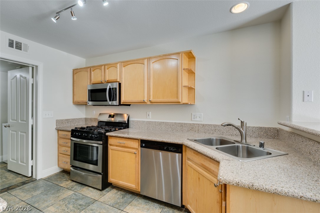 200 Luninborg Street Henderson, NV 89074 - Photo 15 of 40 Culinary adventures await in this kitchen featuring abundant light wood cabinetry and resilient tile flooring.