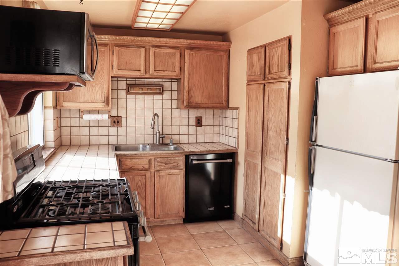 17360 Cold Springs Drive Reno, NV 89508 - Photo 3 of 16 a kitchen with granite countertop a refrigerator and a stove