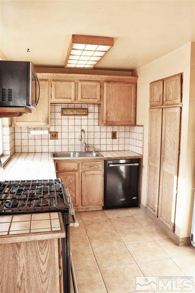 17360 Cold Springs Drive Reno, NV 89508 - Photo 4 of 16 a kitchen with a stove a sink and a microwave