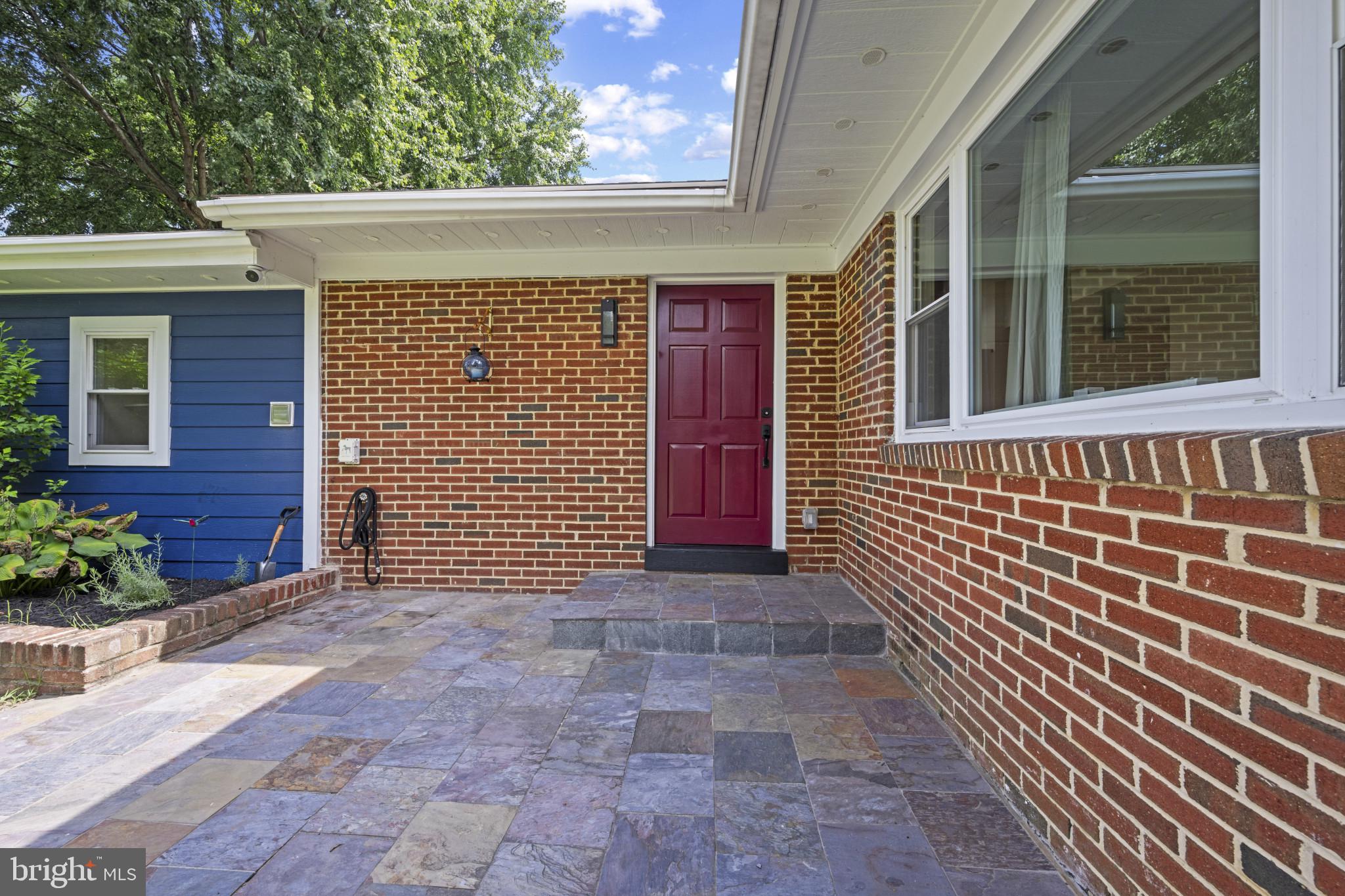 A stone patio leads to the front door