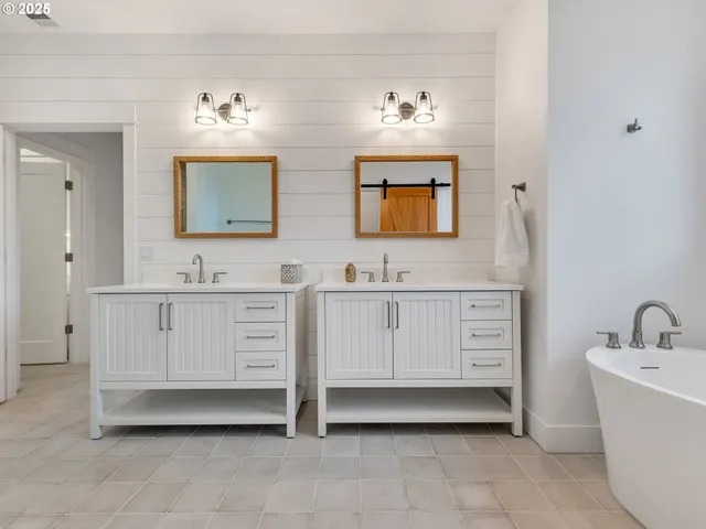 a bathroom with double vanity sink a mirror and bathtub