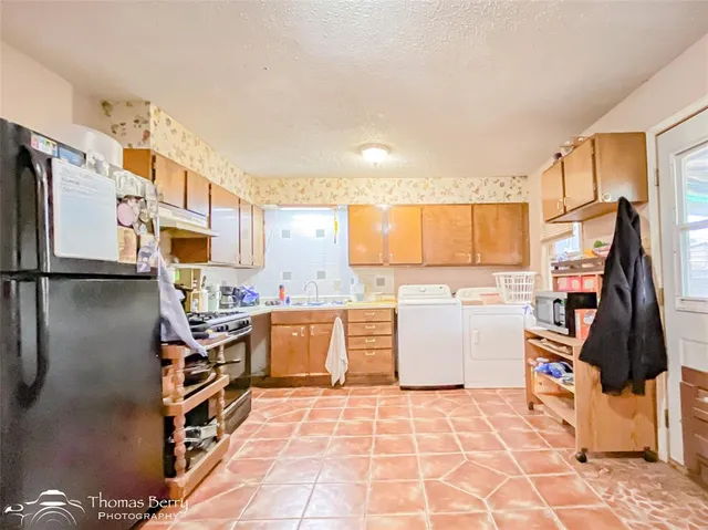 a kitchen with a sink refrigerator and cabinets