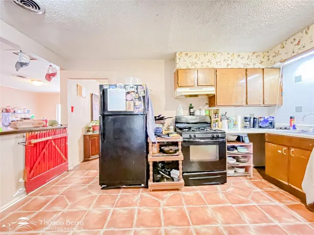 a kitchen with stainless steel appliances granite countertop a refrigerator stove top oven and sink