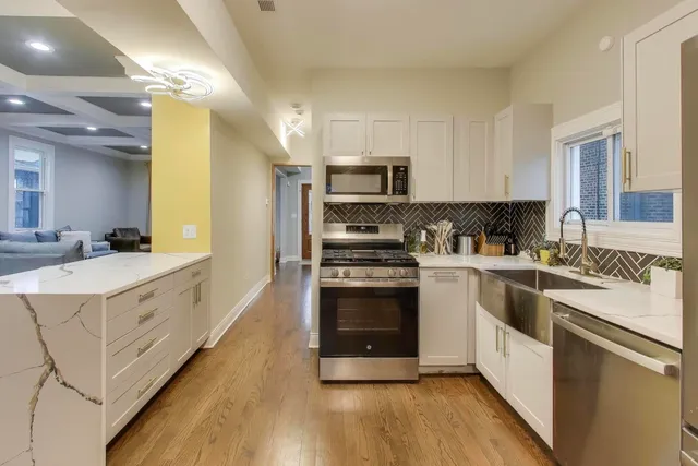 a kitchen with stainless steel appliances granite countertop a stove a sink and a refrigerator