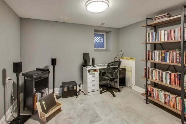 a view of a workspace with furniture and a bookshelf
