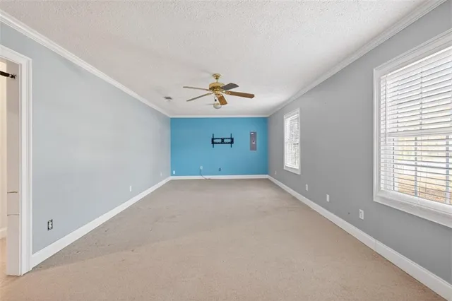 a view of a room with a ceiling fan and window