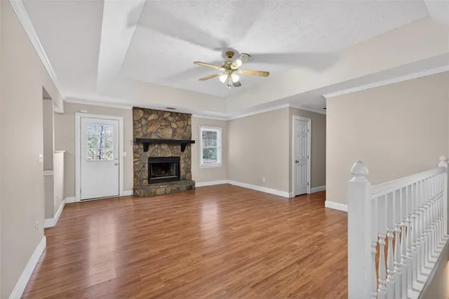 a view of a livingroom with a fireplace a ceiling fan and closet area