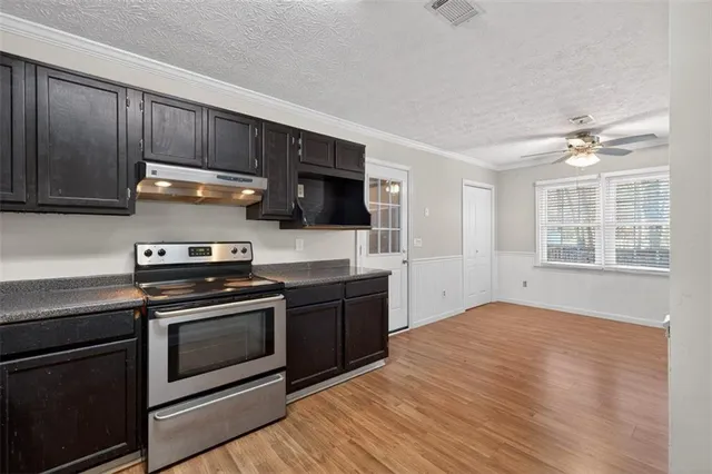 a kitchen with wooden floors and stainless steel appliances