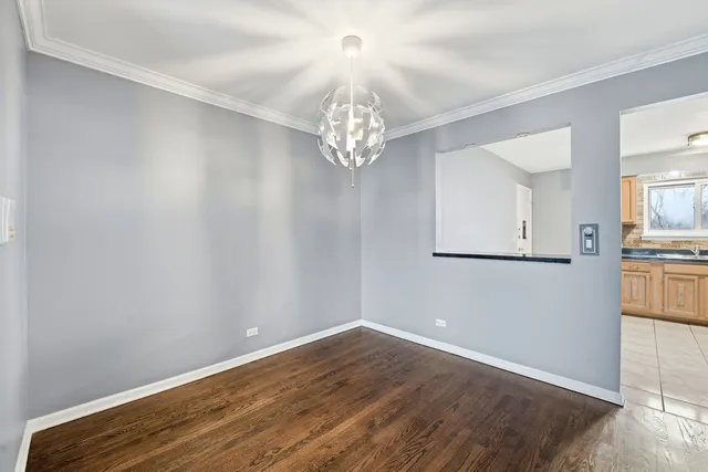a view of a hallway with wooden floor and a kitchen