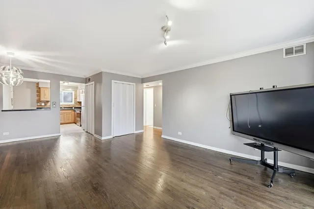 a view of a livingroom with wooden floor and furniture