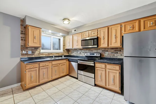 a kitchen with granite countertop cabinets stainless steel appliances and a counter space