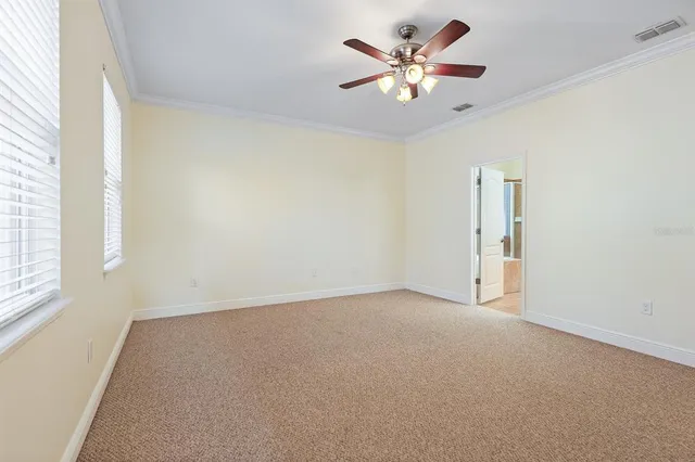 an empty room with a window and a fan