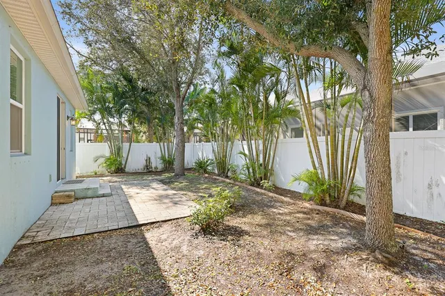 a view of a yard with plants and trees