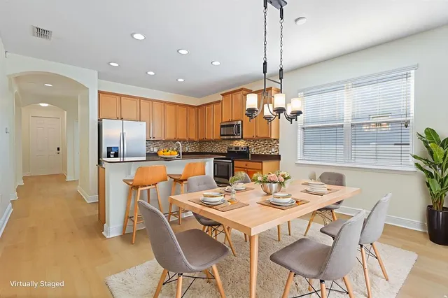 a dining room with furniture a chandelier and kitchen view