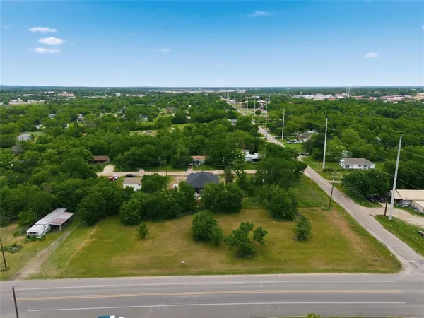 an aerial view of residential houses with outdoor space and trees