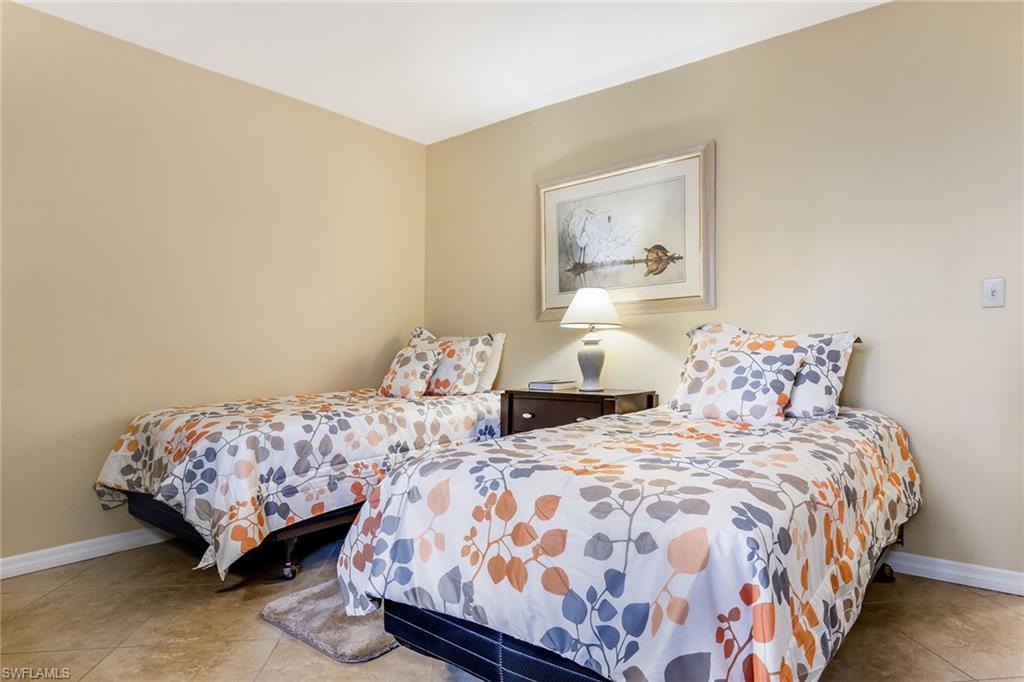 1075 Foxfire Lane, Unit 103 Naples, FL 34104 - Photo 14 of 20 a bedroom with two beds and painting on the wall