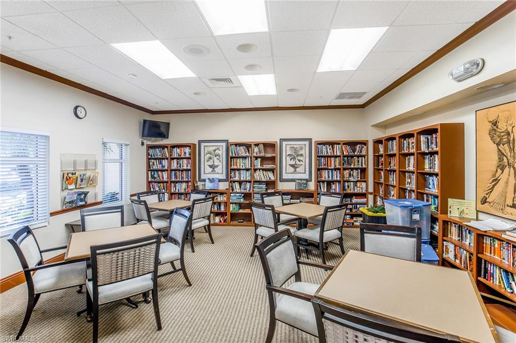 1075 Foxfire Lane, Unit 103 Naples, FL 34104 - Photo 19 of 20 a living room with lots of furniture and a book shelf