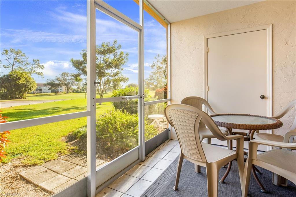 1075 Foxfire Lane, Unit 103 Naples, FL 34104 - Photo 4 of 20 a view of a porch with furniture and a yard