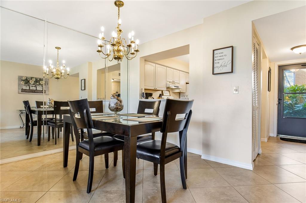 1075 Foxfire Lane, Unit 103 Naples, FL 34104 - Photo 7 of 20 a view of a dining room with furniture and chandelier