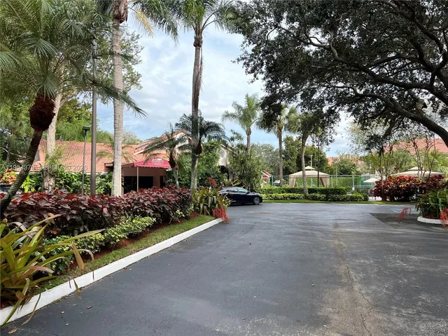 a view of a street with a building and trees in the background