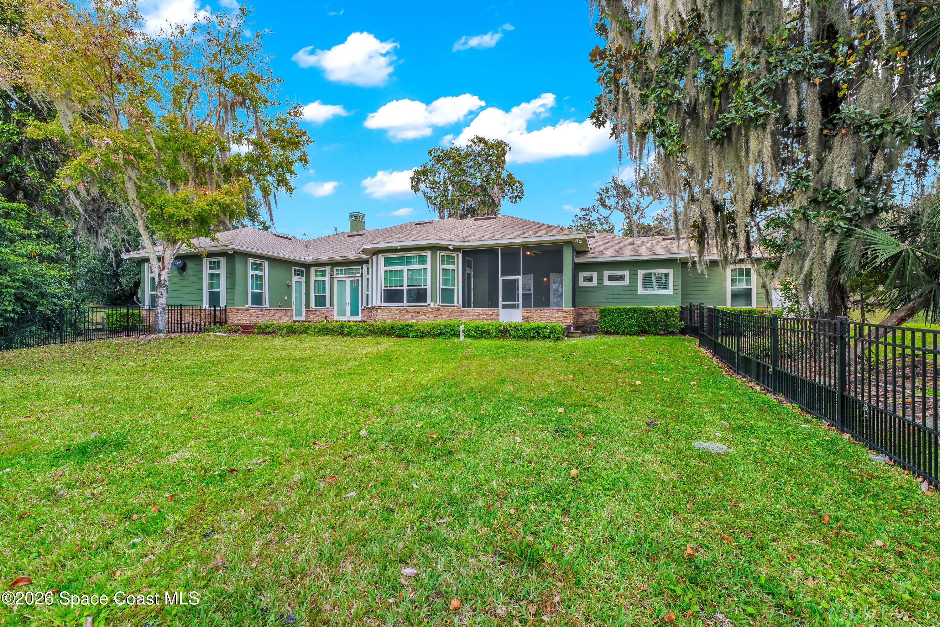 4150 Heller Road Titusville, FL 32796 - Photo 17 of 65 a view of a house next to a big yard and large trees