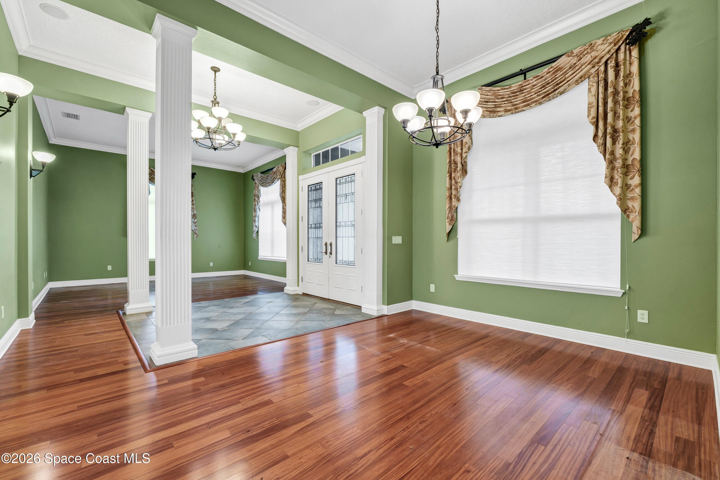 4150 Heller Road Titusville, FL 32796 - Photo 22 of 65 a view of a hallway with wooden floor and a chandelier