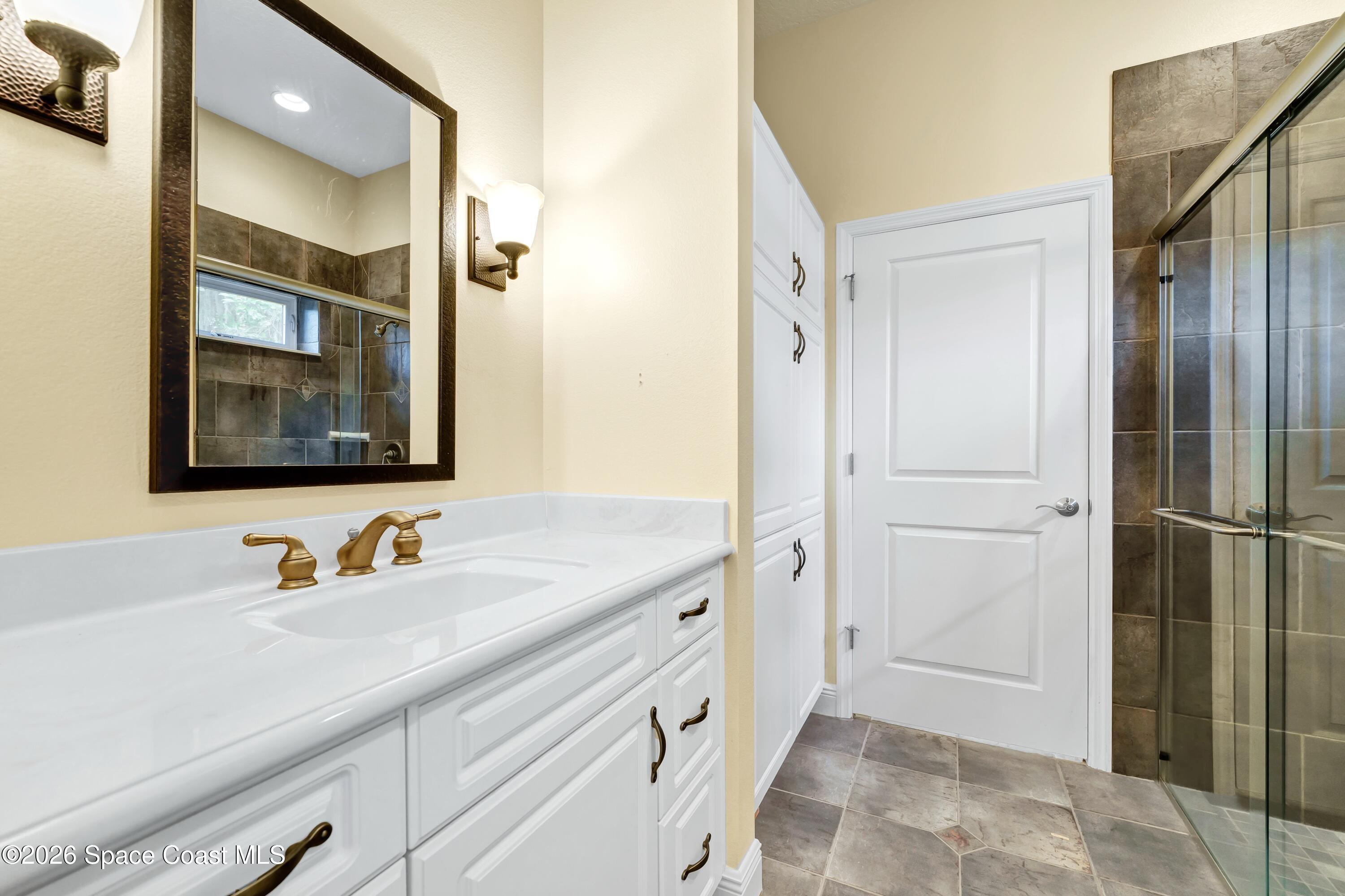 4150 Heller Road Titusville, FL 32796 - Photo 47 of 65 a bathroom with a double vanity sink and mirror