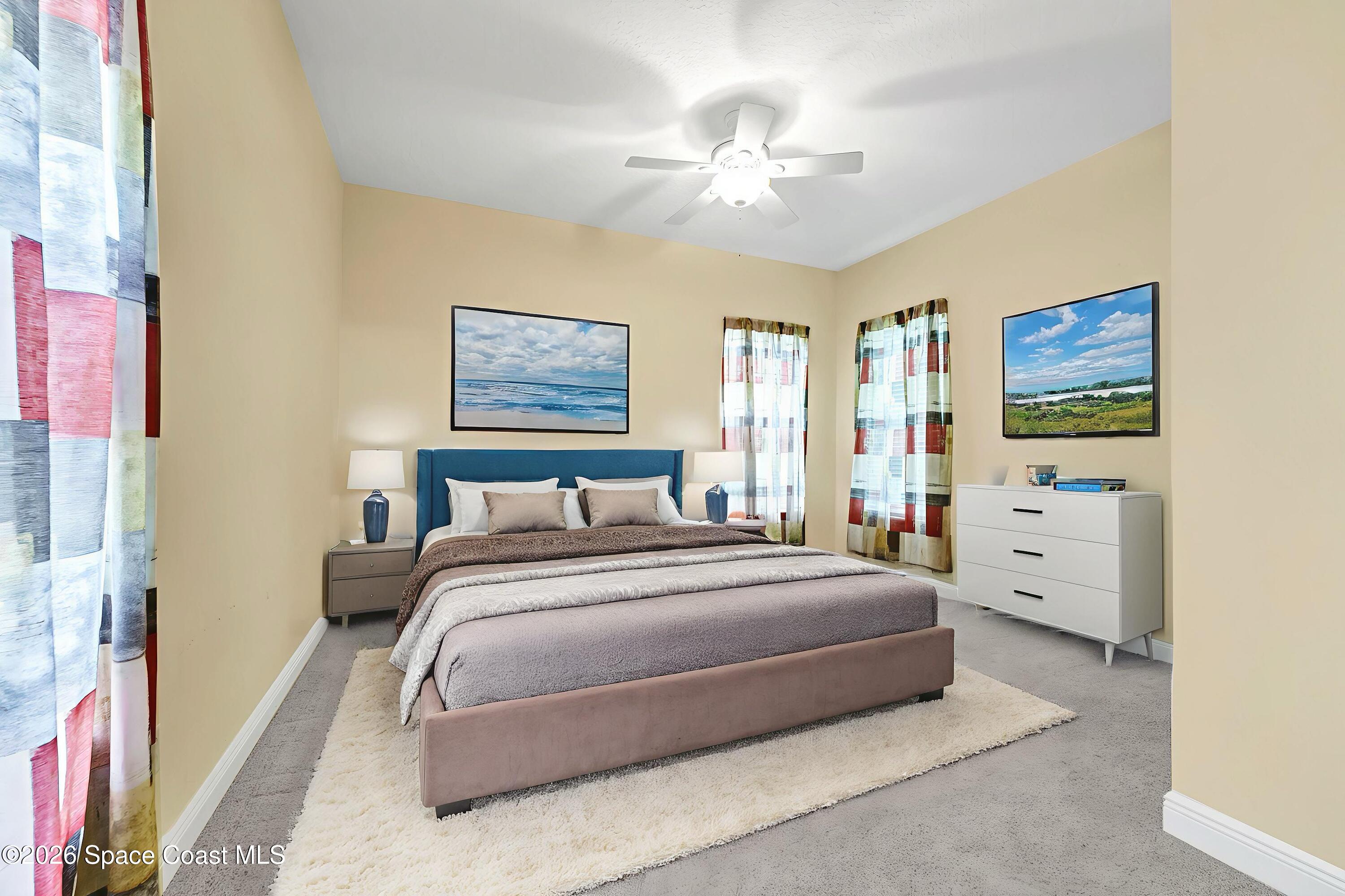 4150 Heller Road Titusville, FL 32796 - Photo 48 of 65 a spacious bedroom with a bed and a chandelier