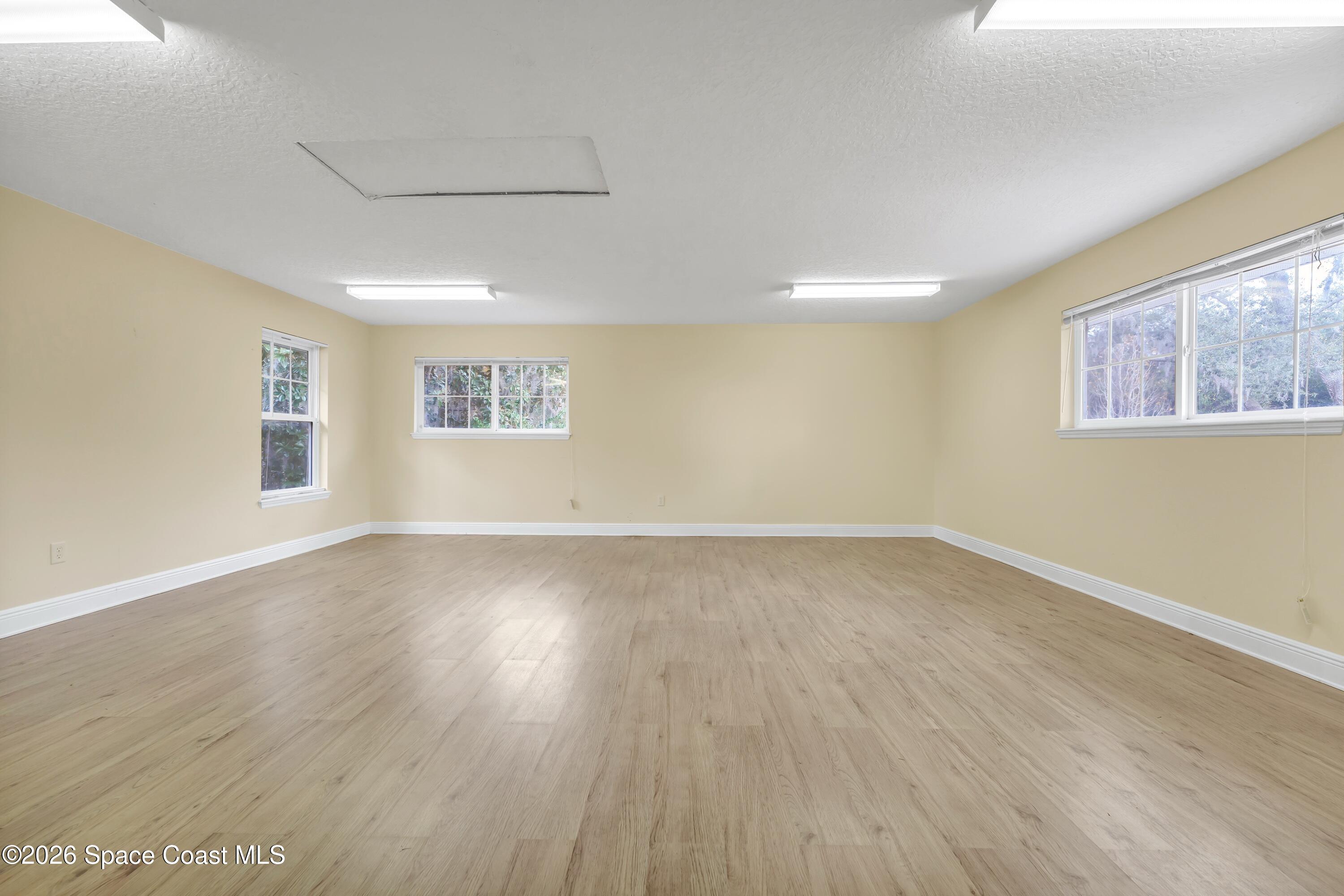 4150 Heller Road Titusville, FL 32796 - Photo 52 of 65 a view of an empty room with wooden floor and a window