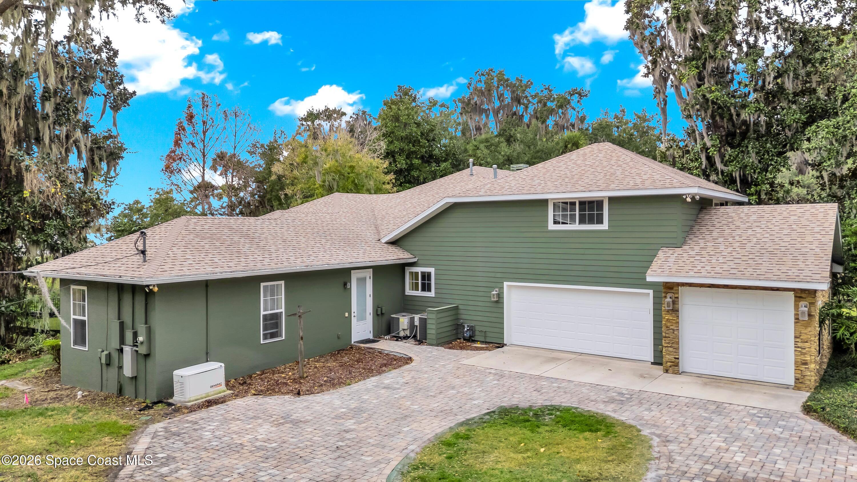 4150 Heller Road Titusville, FL 32796 - Photo 54 of 65 a front view of a house with a garden and tree