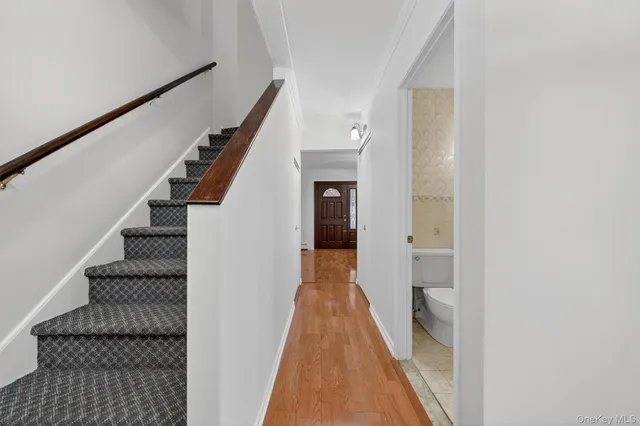 a view of a hallway with wooden floor and staircase
