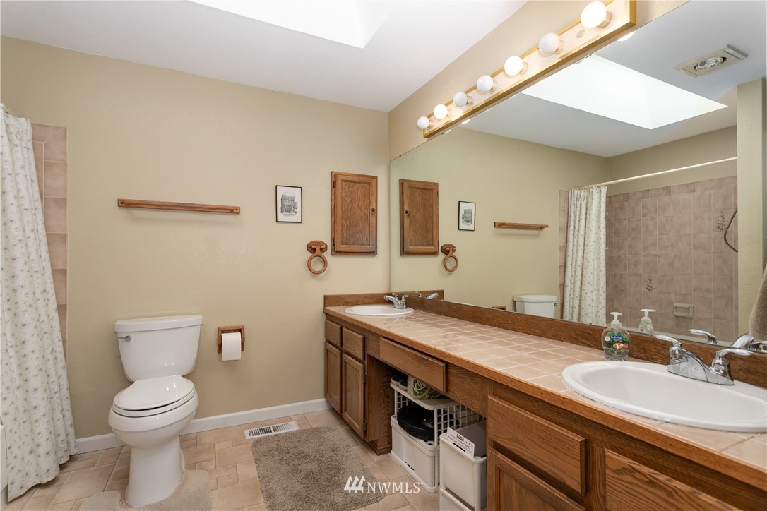 2003 237th Street Southeast Bothell, WA 98021 - Photo 17 of 25 a spacious bathroom with a granite countertop sink a toilet and a mirror