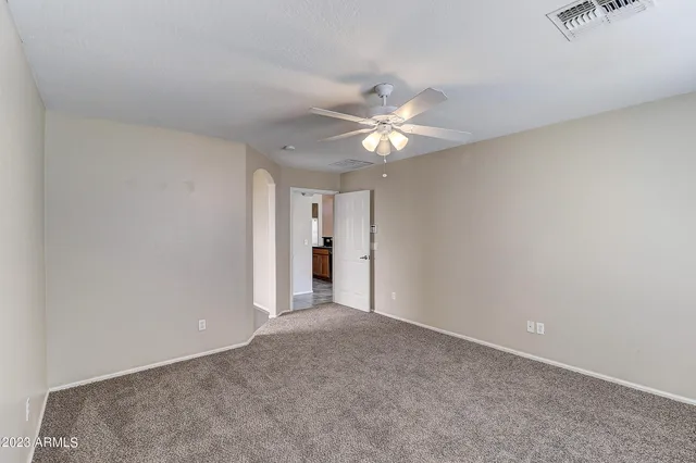 an empty room with a ceiling fan and a window