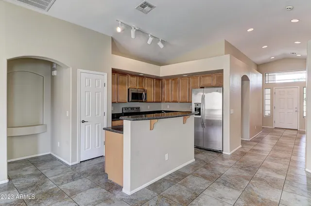 a kitchen with stainless steel appliances granite countertop a refrigerator and a sink