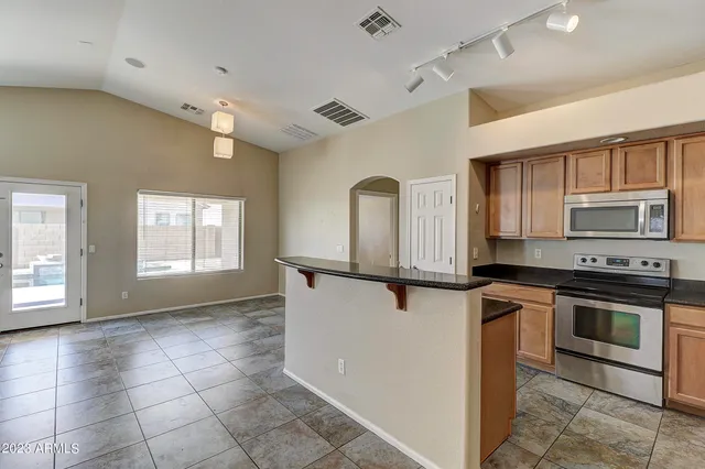 a kitchen with stainless steel appliances granite countertop a stove a sink and a refrigerator