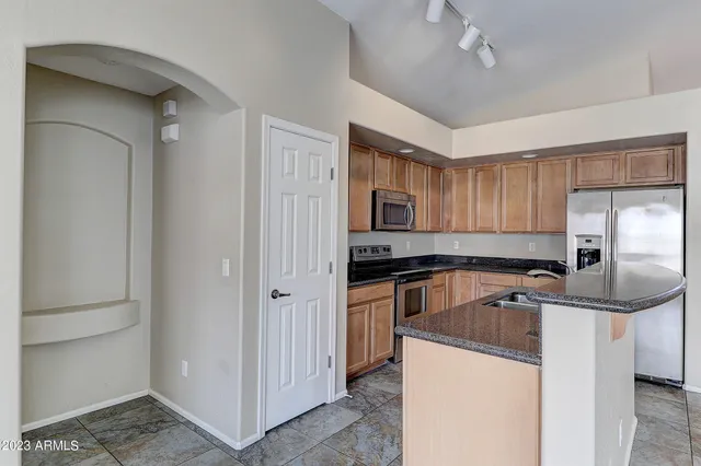 a kitchen with stainless steel appliances granite countertop a refrigerator and a sink