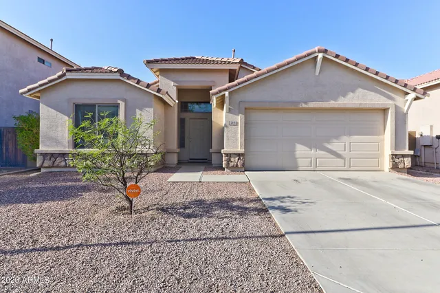 a front view of a house with a yard and potted plants