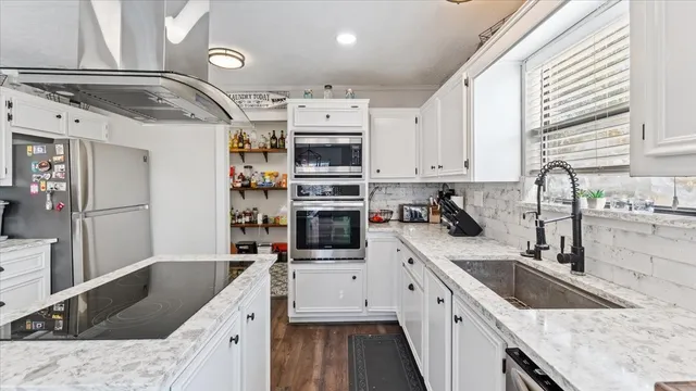a kitchen with stainless steel appliances granite countertop a sink stove and refrigerator