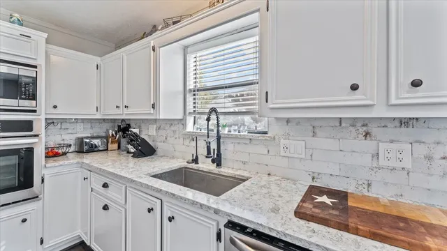 a kitchen with stainless steel appliances granite countertop a sink stove and cabinets